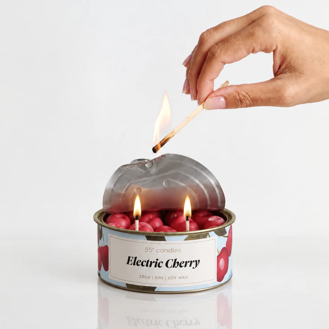 Свещ „Electric Cherry“ в метална кутия, върху рисувана илюстрация