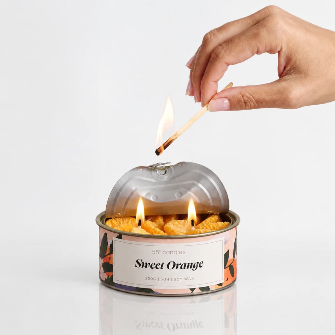 Свещ „Sweet Orange“ в метална кутия, върху рисувана илюстрация
